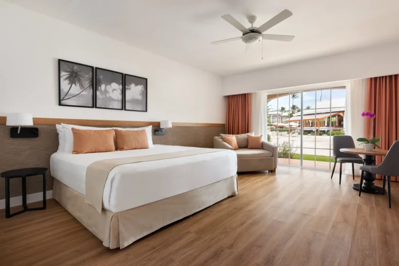 Superior Deluxe Pool View room with king-size bed and terrace at Sunscape Coco Punta Cana overlooking the pool area.