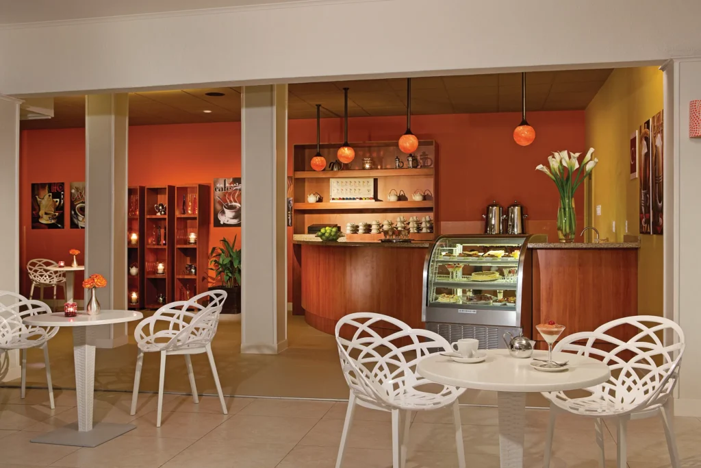 Coco Café at Sunscape Curaçao Resort featuring a cozy coffee bar, pastry display case, and modern café seating.