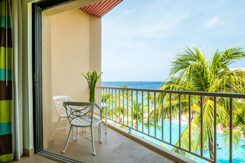 Private ocean view balcony with seating at Deluxe Ocean View room in Sunscape Curaçao Resort.
