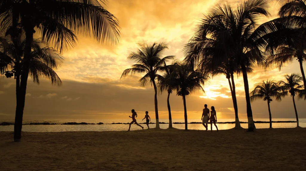 Family walking along the beach at sunset at Sunscape Curaçao Resort, Spa & Casino.
