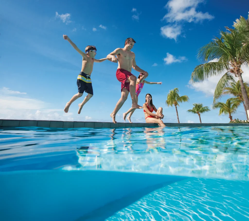 Family jumping into a pool together at Sunscape Curaçao Resort, Spa & Casino.