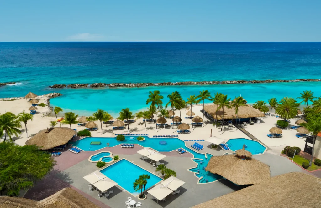 Resort pools and beachfront with palapa umbrellas at Sunscape Curaçao Resort, Spa & Casino in the Caribbean.