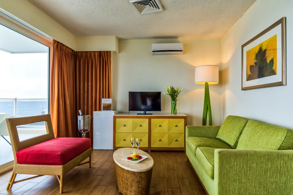 Presidential Suite living room with sofa, lounge chair, and entertainment area at Sunscape Curaçao Resort.
