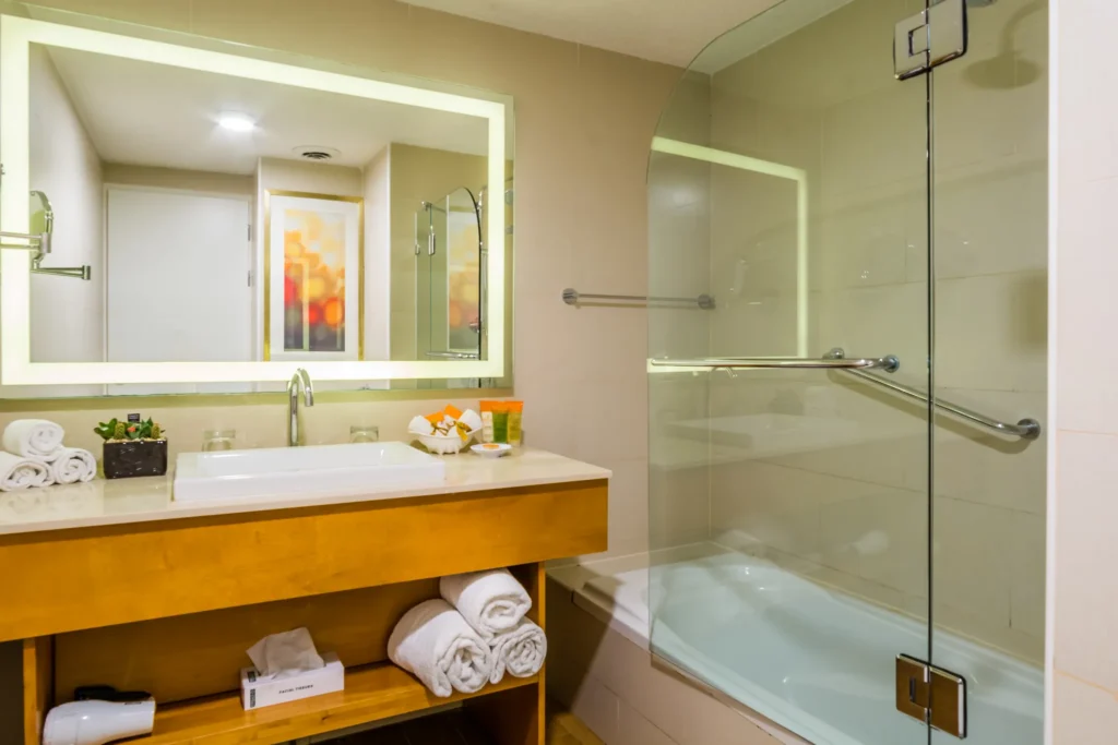 Sun Club Deluxe Ocean View bathroom with modern vanity and tub shower at Sunscape Curaçao Resort.