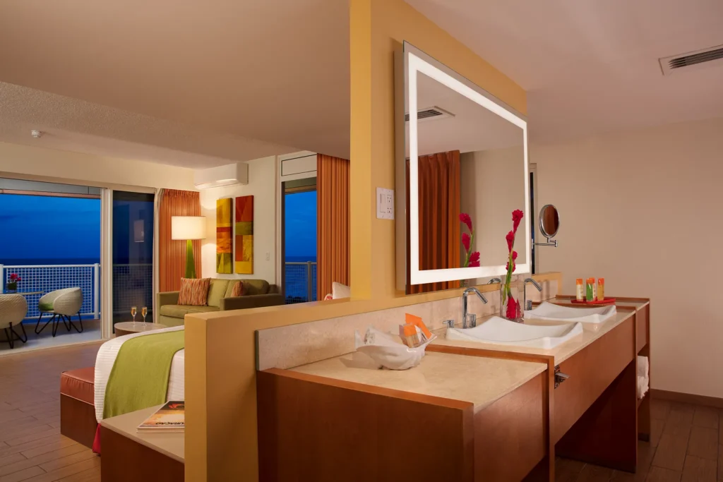 Sun Club Honeymoon Junior Suite bathroom with double vanity sinks and illuminated mirror at Sunscape Curaçao Resort.