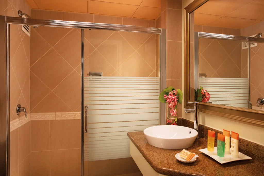 Sun Club Premium Deluxe Ocean Front bathroom with vanity sink and glass shower at Sunscape Curaçao Resort.