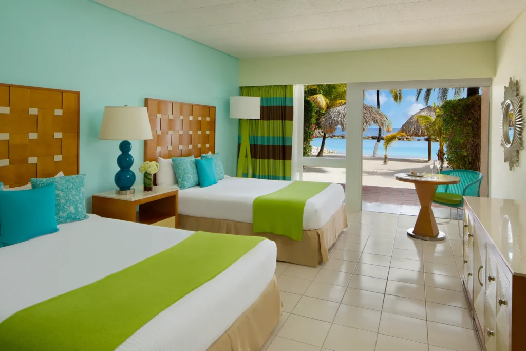Sun Club Premium Deluxe Ocean Front room with two double beds and ocean-view terrace at Sunscape Curaçao Resort.