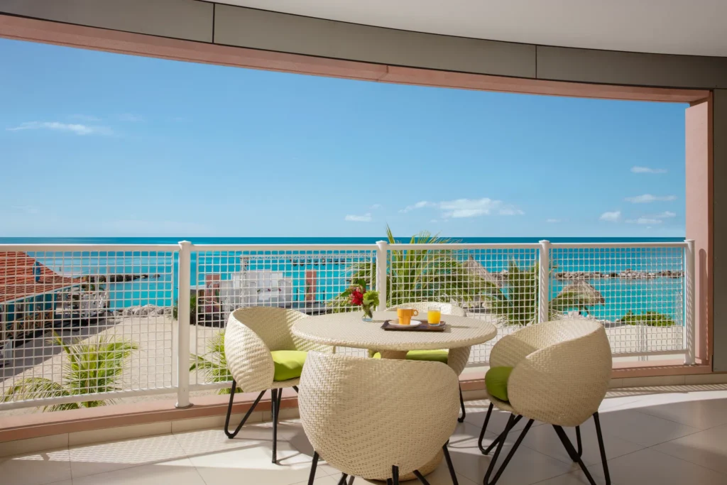 Sun Club Suite Ocean Front private terrace with dining table and Caribbean Sea views at Sunscape Curaçao Resort.