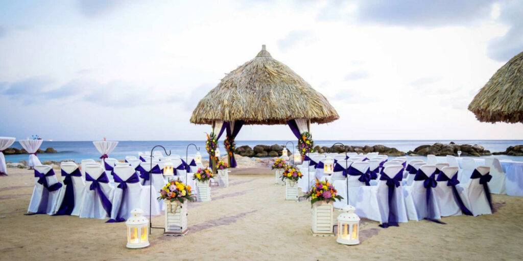 Beach wedding ceremony setup with thatched gazebo and ocean view at Sunscape Curaçao Resort, Spa & Casino