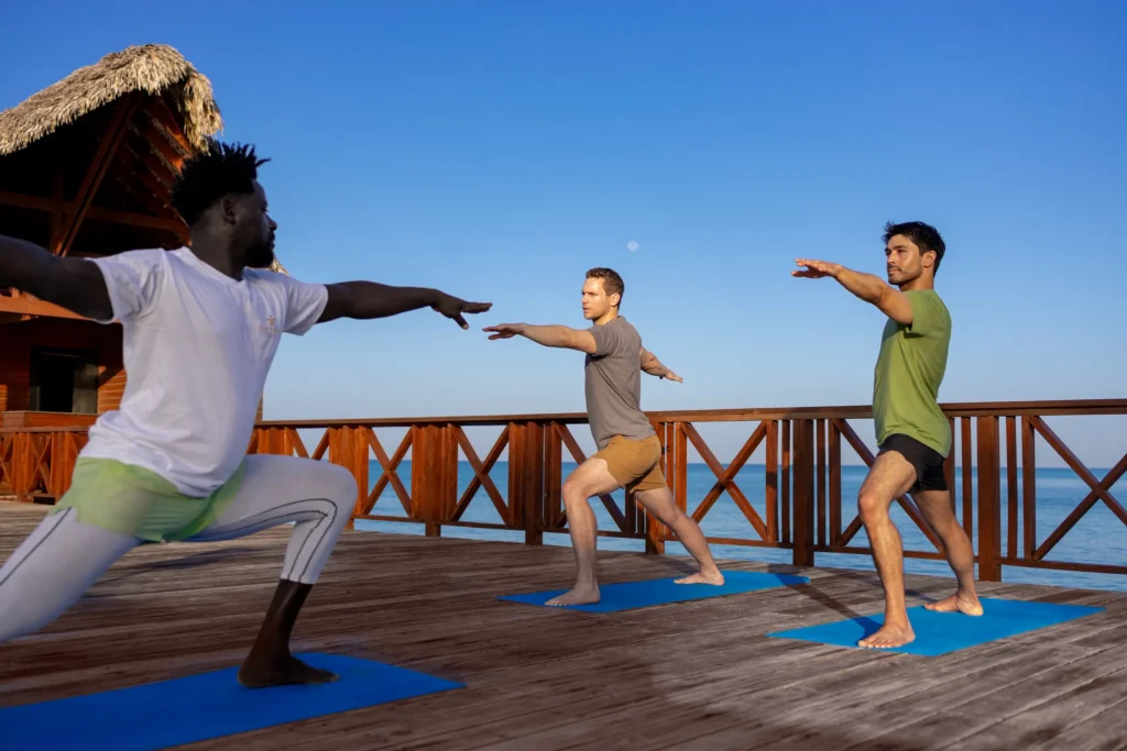 Guests practicing yoga on a deck by the ocean at Sunscape Dominicus La Romana.