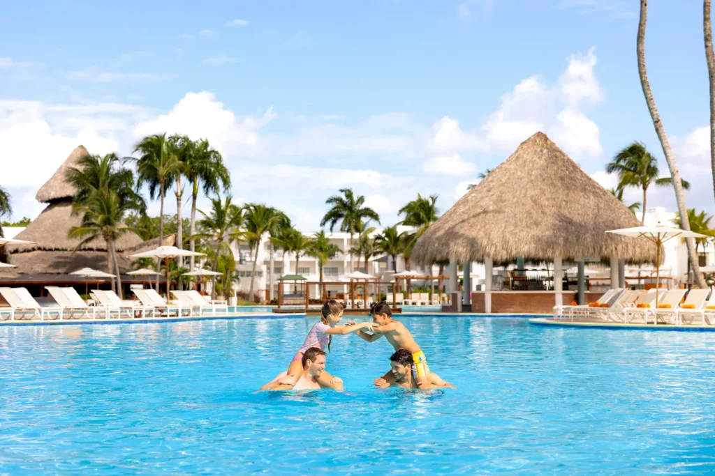 Family playing together in a large resort pool at Sunscape Dominicus La Romana.