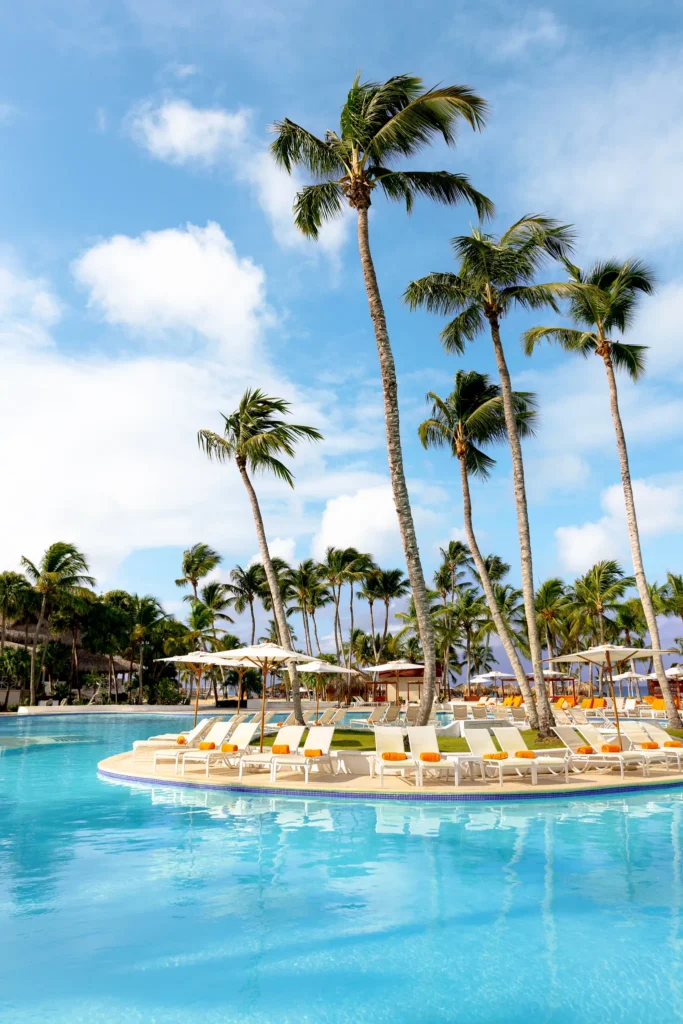 Tropical main pool with palm trees and loungers at Sunscape Dominicus La Romana, offering a relaxing family-friendly Caribbean setting.