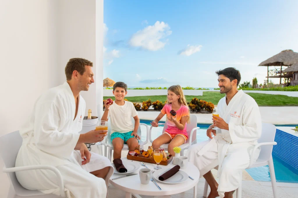 Family sharing breakfast and drinks by a poolside terrace at Sunscape Dominicus La Romana.