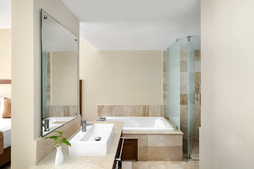 Sun Club Junior Suite Tropical View bathroom with soaking tub, glass walk-in shower, and modern vanity at Sunscape Dominicus La Romana.