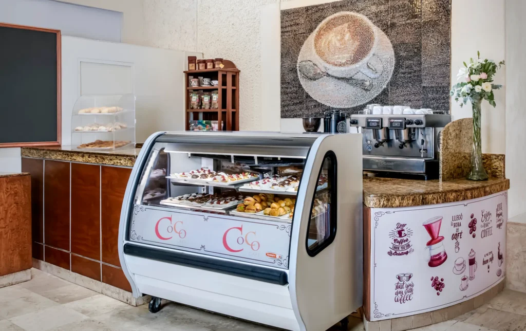 Coco Café at Sunscape Dorado Pacifico Ixtapa featuring a coffee bar, espresso machine, pastry display case, and casual café seating.