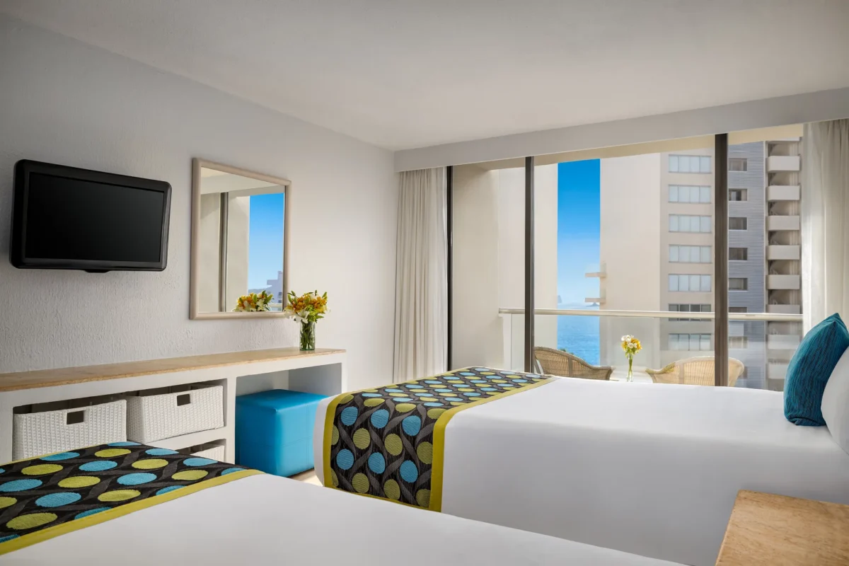 Deluxe Partial Ocean View room with two double beds and private balcony at Sunscape Dorado Pacifico Ixtapa.