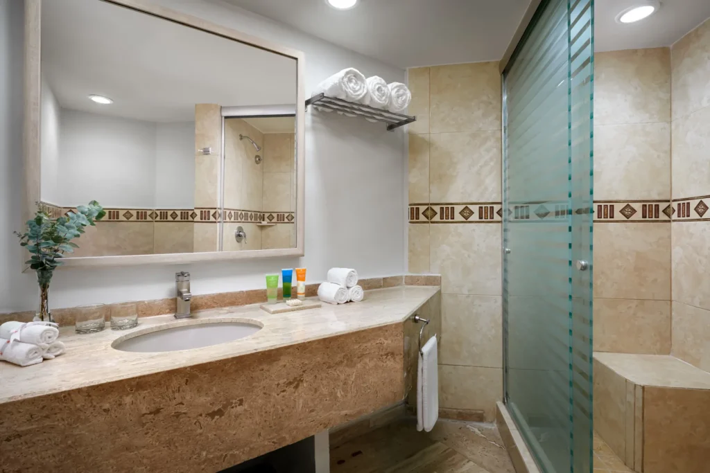 Sun Club Honeymoon Suite bathroom with marble vanity and glass walk-in shower at Sunscape Dorado Pacifico Ixtapa.