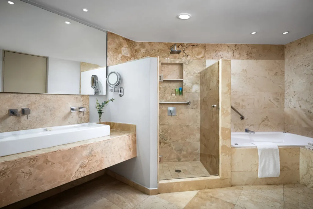 Sun Club Presidential Suite bathroom with marble finishes, walk-in shower and soaking tub at Sunscape Dorado Pacifico Ixtapa.