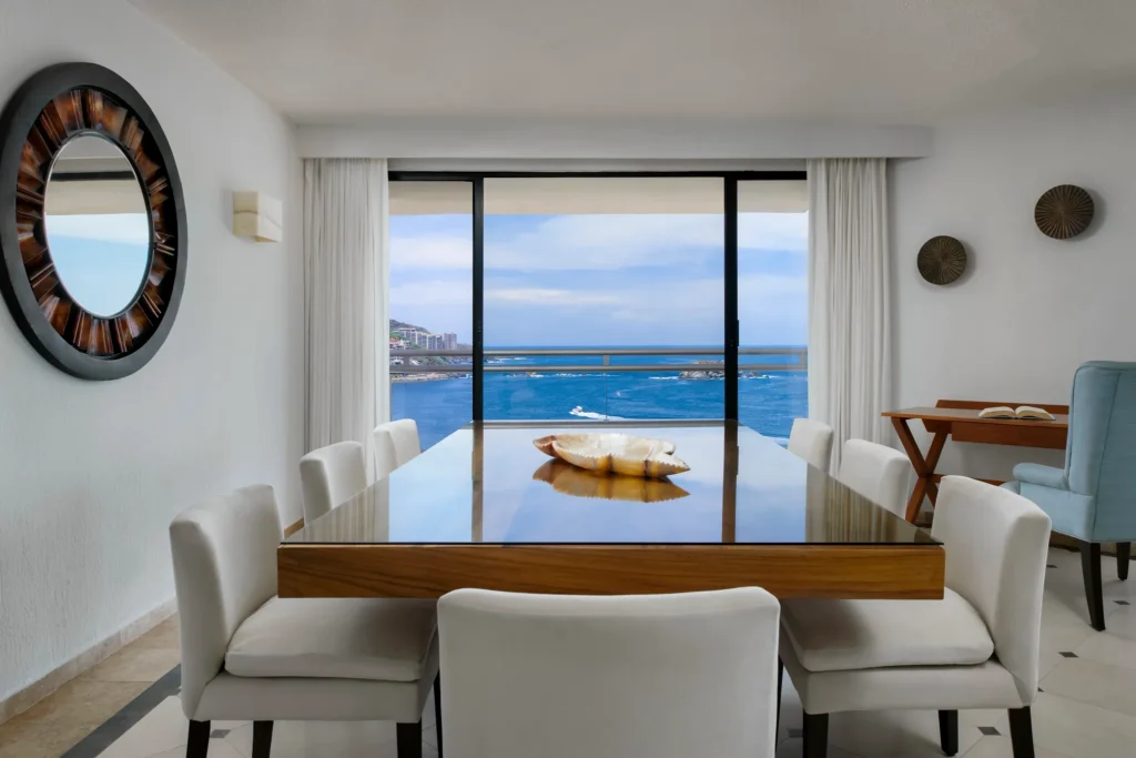 Sun Club Presidential Suite dining area with table for six and oceanfront balcony view at Sunscape Dorado Pacifico Ixtapa.