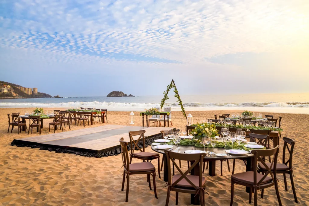 Beach wedding reception setup with wooden tables and ocean views at Sunscape Dorado Pacifico Ixtapa