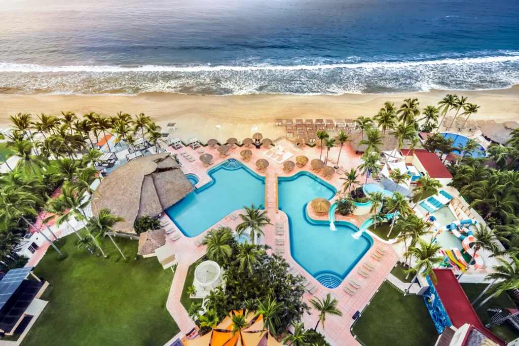 Aerial view of main pool and waterslides at Sunscape Dorado Pacifico Ixtapa overlooking the Pacific Ocean.