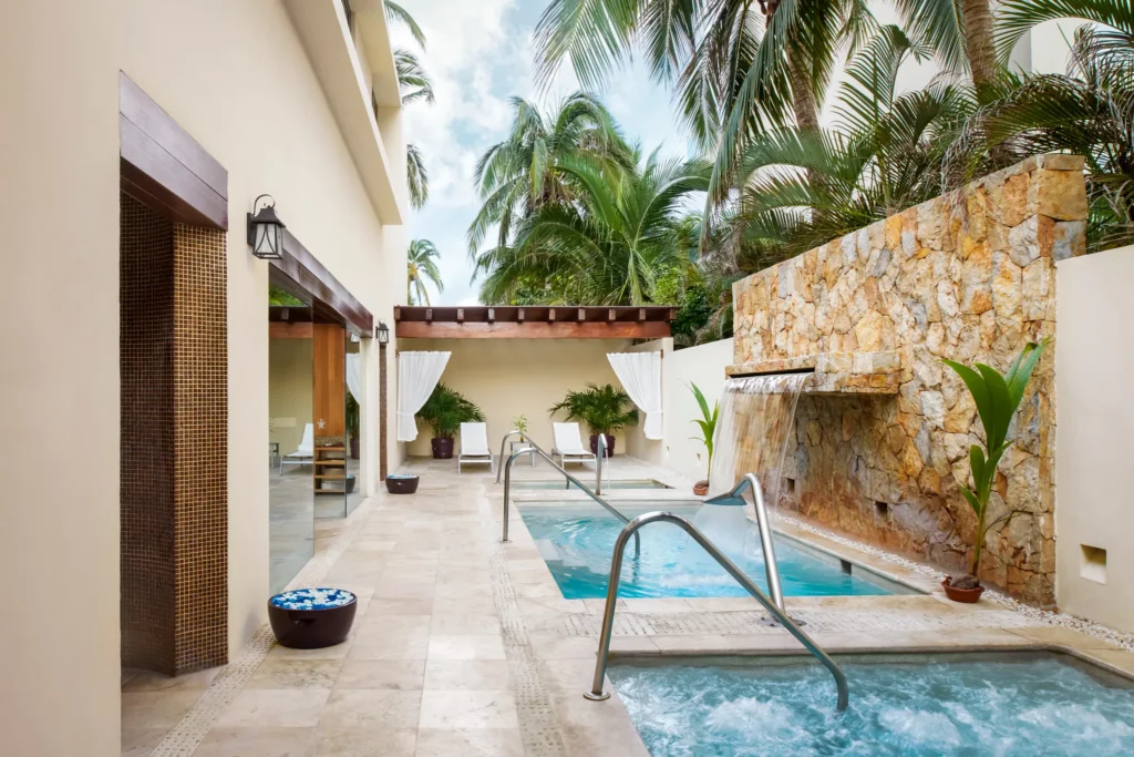 Outdoor hydrotherapy pool with waterfall feature at Sunscape Dorado Pacifico Ixtapa spa.