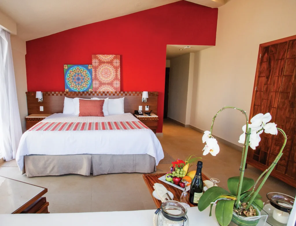 Sun Club Romantic Ocean Front suite with king bed and elegant décor at Sunscape Puerto Vallarta Resort & Spa.