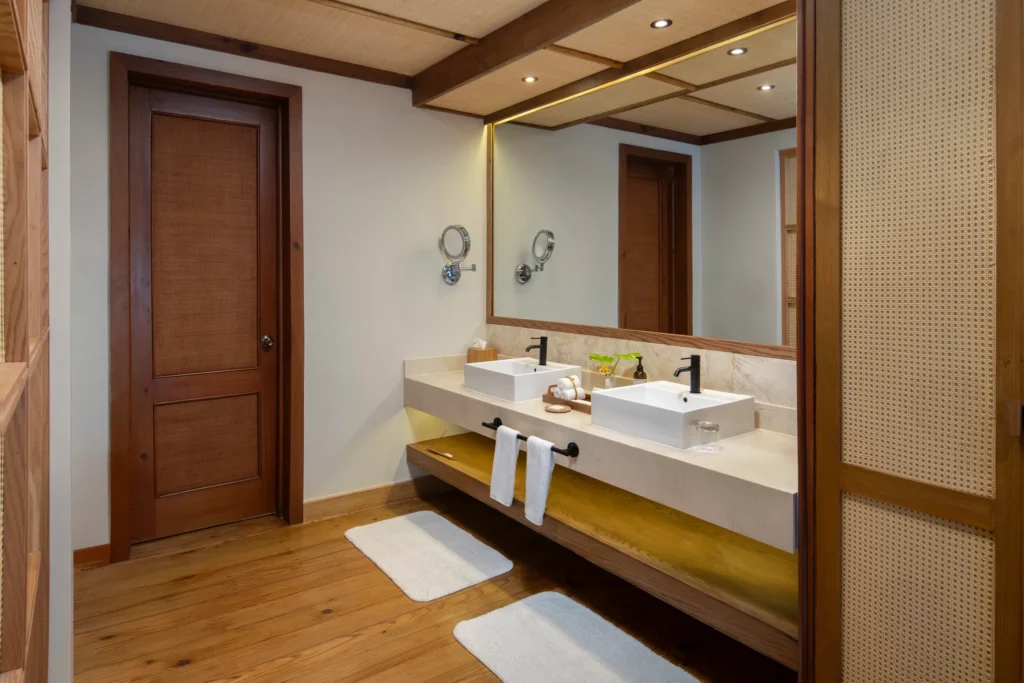 Junior Suite Oceanfront bathroom with double vanity and coral stone finishes at Zoëtry Agua Punta Cana.