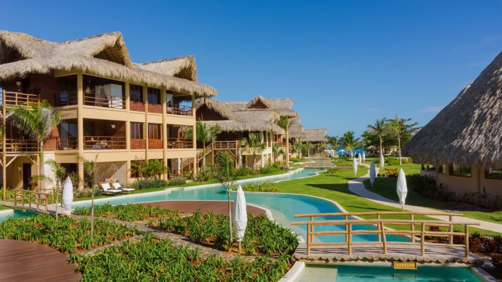 Caribbean-style buildings with lagoon-style pool and tropical gardens at Zoëtry Agua Punta Cana.