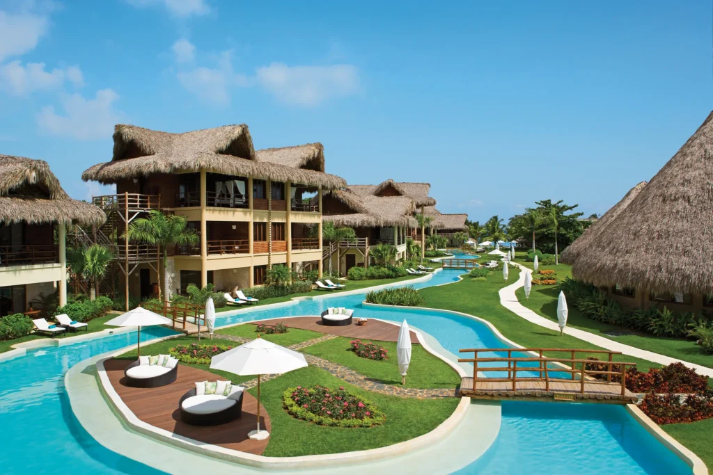 Panoramic daytime view of lagoon-style pool and suites at Zoëtry Agua Punta Cana.