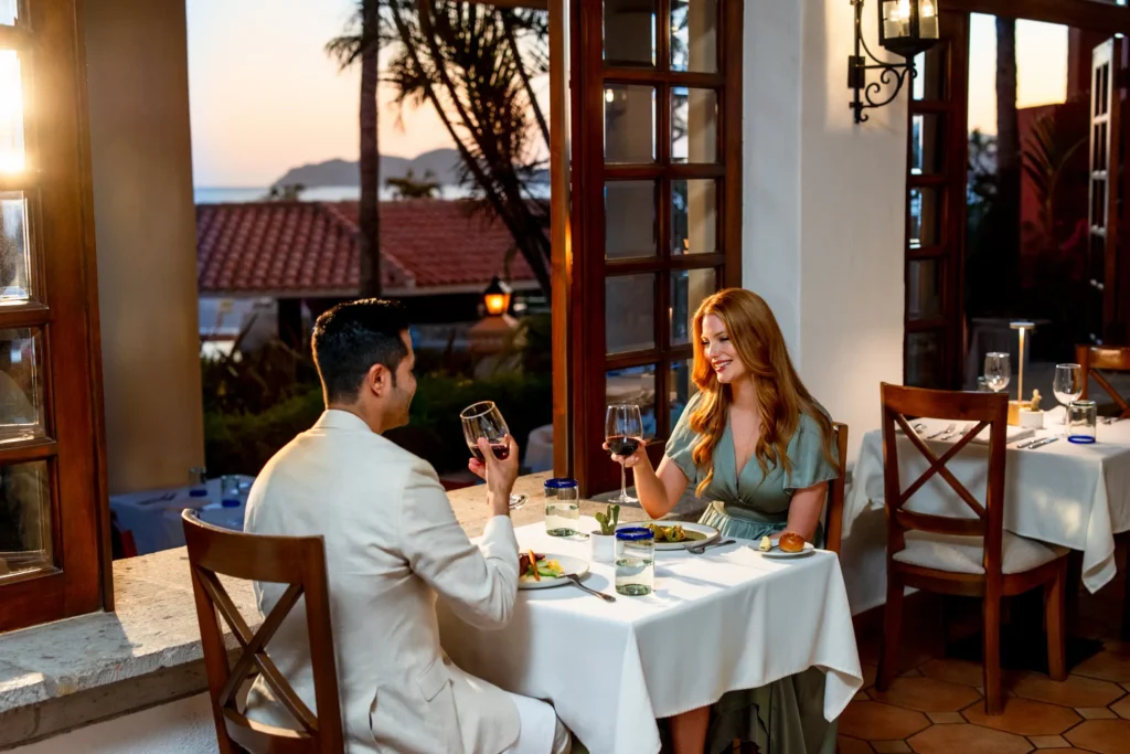 Couple enjoying romantic dinner with wine at Zoëtry Casa del Mar Los Cabos during sunset.