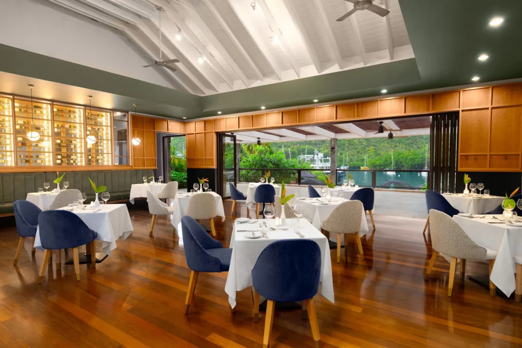 1461 restaurant at Zoëtry Marigot Bay St. Lucia featuring elegant indoor dining, white table settings, and panoramic marina views.