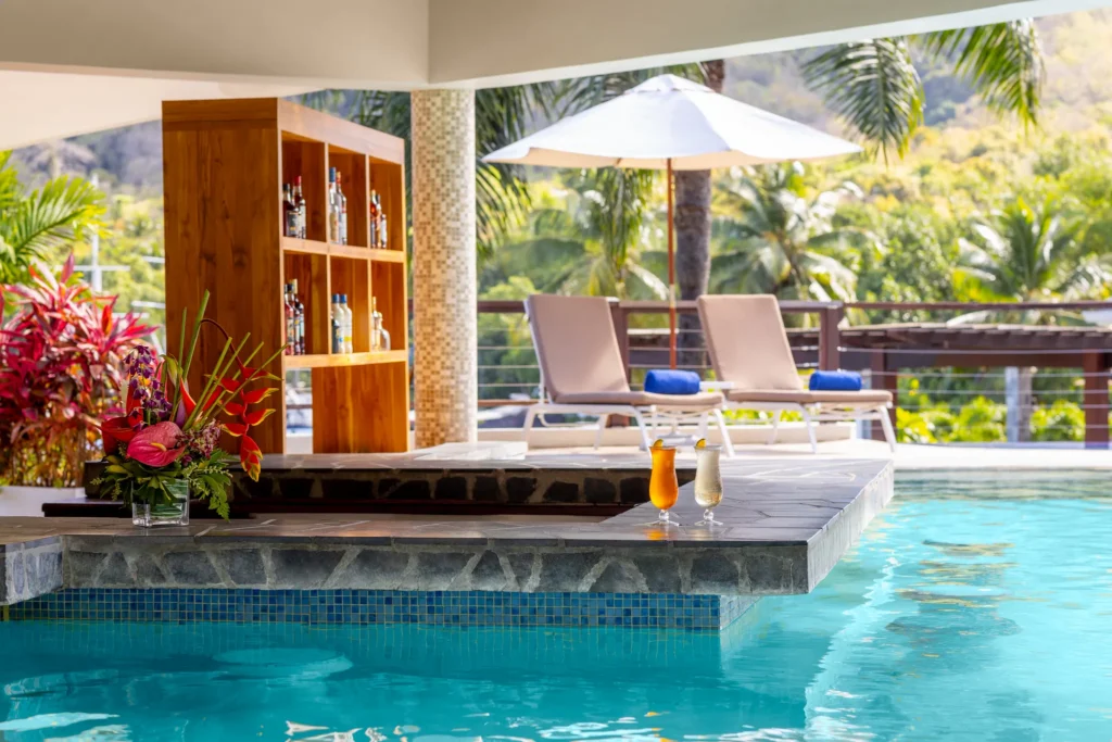 Le Bateau Pool Bar at Zoëtry Marigot Bay St. Lucia featuring a swim-up bar in the main pool with tropical cocktails and lush marina views.