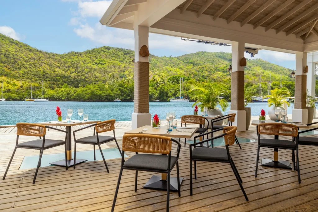 The Hurricane Hole restaurant at Zoëtry Marigot Bay St. Lucia featuring waterfront terrace dining with panoramic marina and hillside views.