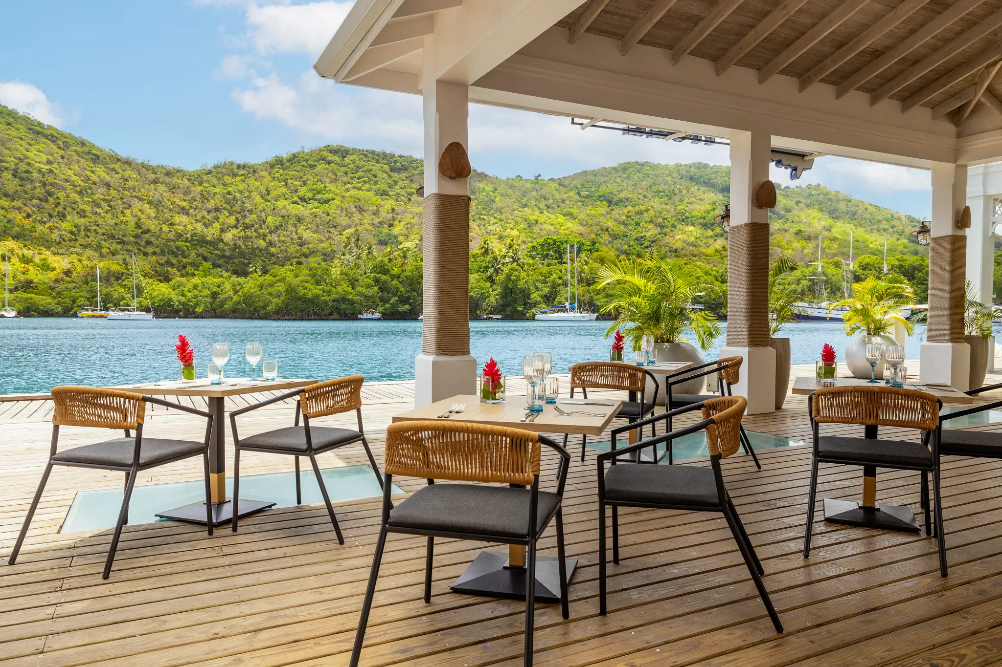 The Hurricane Hole restaurant at Zoëtry Marigot Bay St. Lucia featuring waterfront terrace dining with panoramic marina and hillside views.