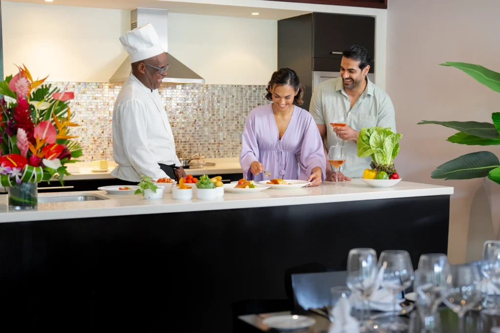 Guests enjoying a private cooking class with a chef at Zoëtry Marigot Bay St. Lucia, preparing fresh Caribbean cuisine.