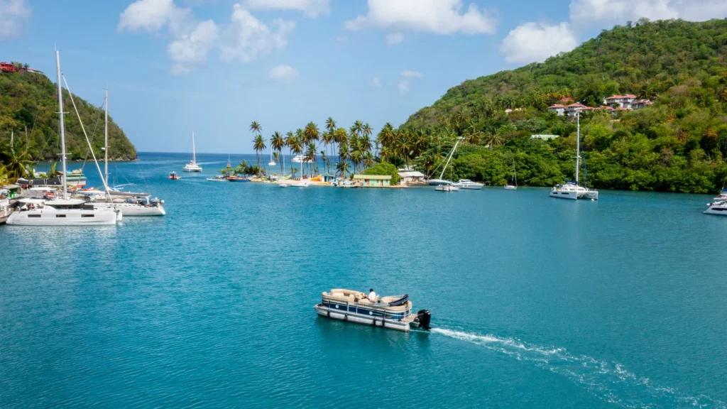 Boat cruising across turquoise waters in Marigot Bay near Zoëtry Marigot Bay St. Lucia.