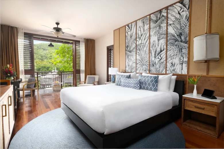 King bedroom with furnished terrace in Junior Suite Garden View at Zoëtry Marigot Bay St. Lucia.
