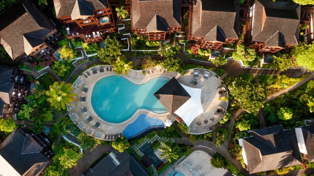 Aerial view of the lagoon-style main pool at Zoëtry Marigot Bay St. Lucia surrounded by tropical landscaping.