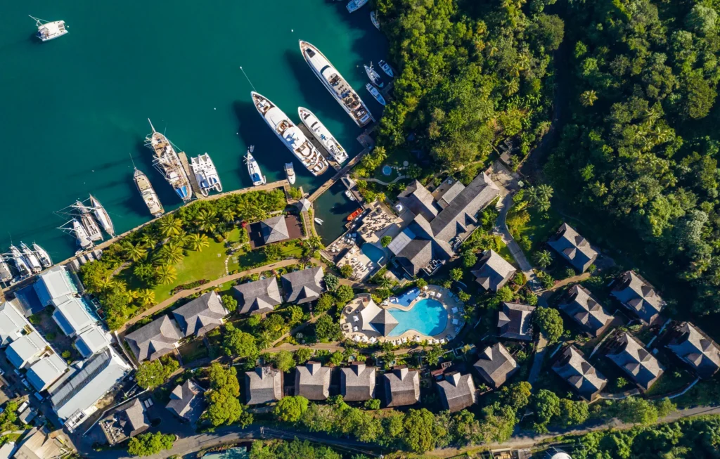 Overhead drone view of Zoëtry Marigot Bay St. Lucia showing marina docks, hillside suites, and tropical landscaping.