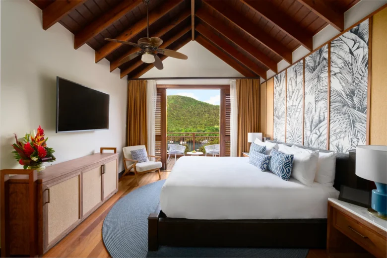 Master bedroom with king bed and balcony view at Zoëtry Marigot Bay Penthouse Residence in St. Lucia.