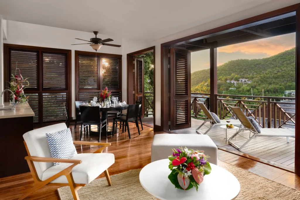 Penthouse living and terrace area at sunset in Zoëtry Marigot Bay St. Lucia overlooking the hills and marina.