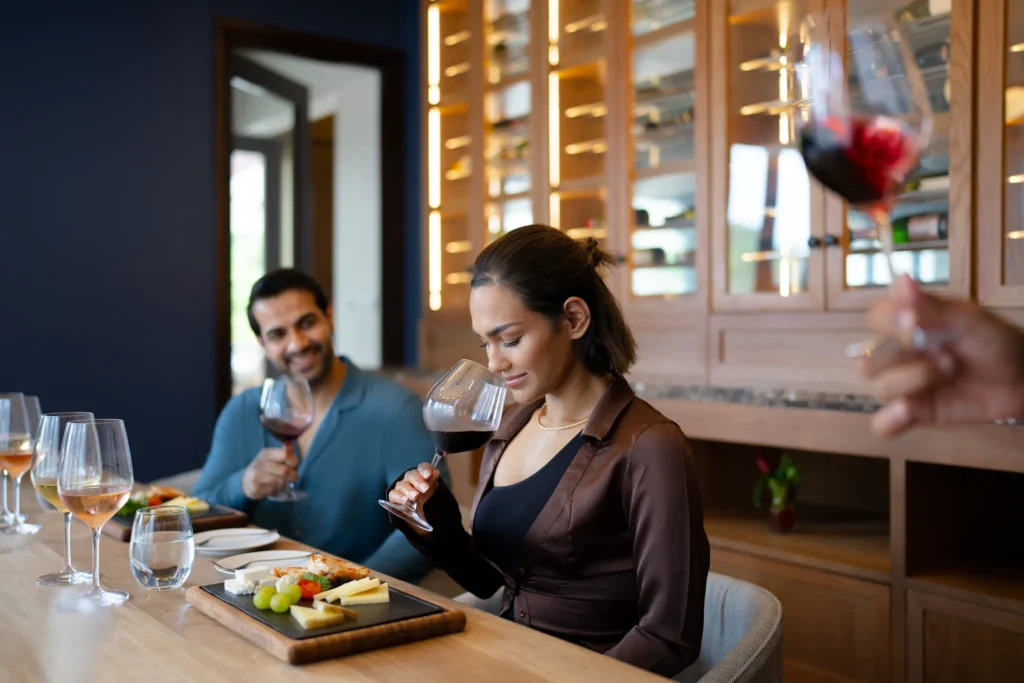 Woman enjoying a red wine tasting with cheese pairing at Zoëtry Marigot Bay St. Lucia’s private wine room.