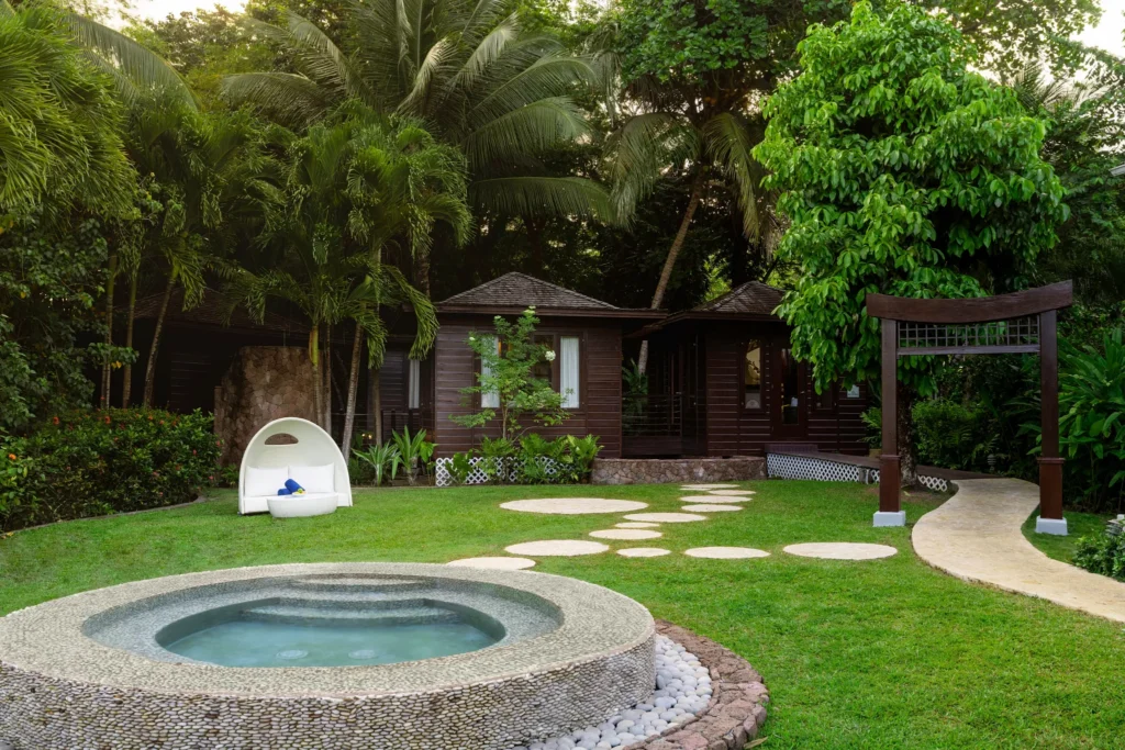 Tropical spa garden with private hot tub and wooden villas at Zoëtry Marigot Bay St. Lucia.