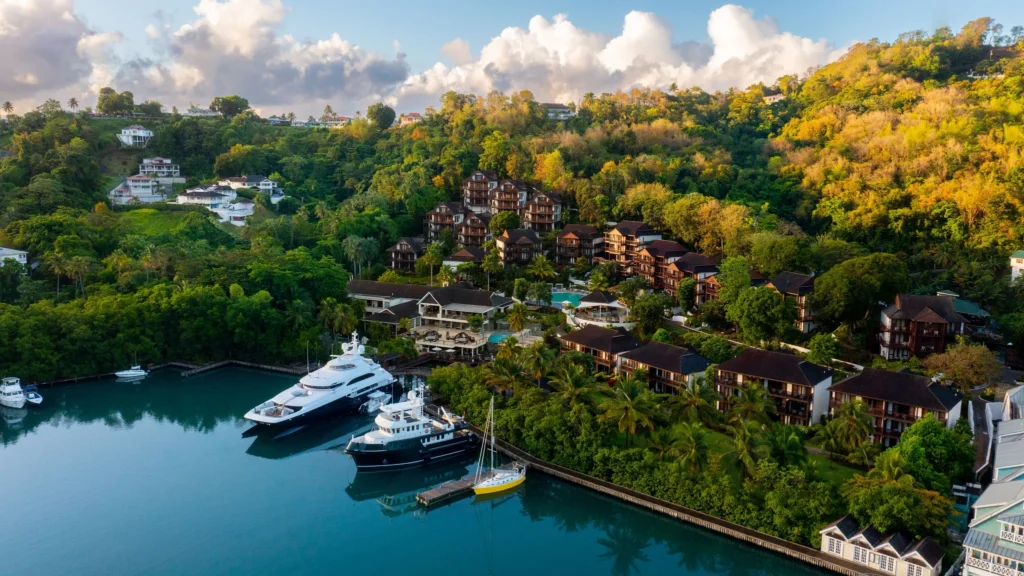 Waterfront perspective of Zoëtry Marigot Bay St. Lucia with marina docks and tropical hillside villas.