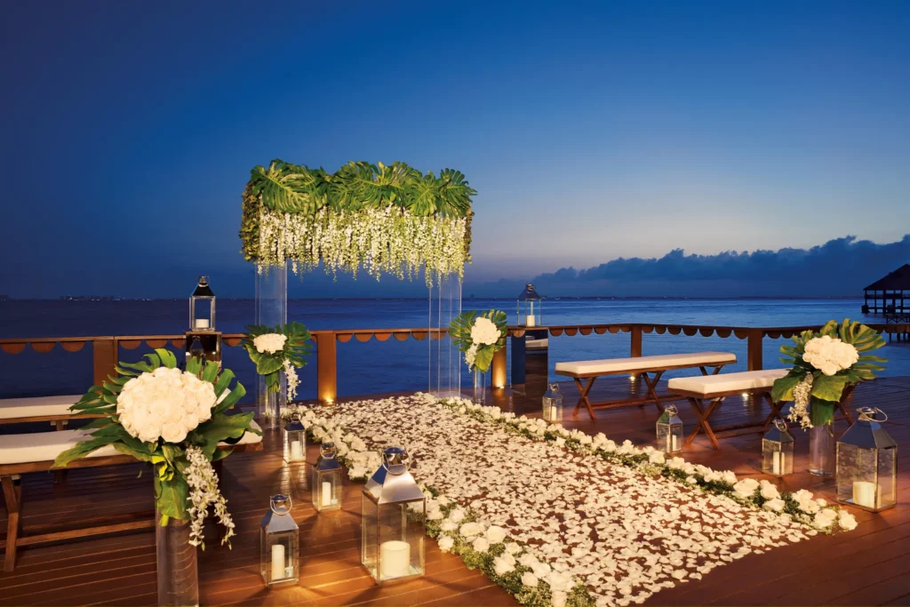 Oceanfront wooden deck wedding venue with pergola and palm trees at Zoëtry Villa Rolandi Isla Mujeres