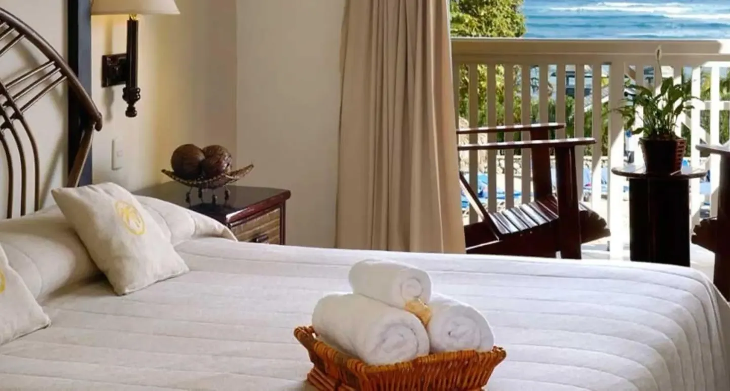 Guest room bed with balcony ocean view at Lifestyle Tropical Beach Resort & Spa.