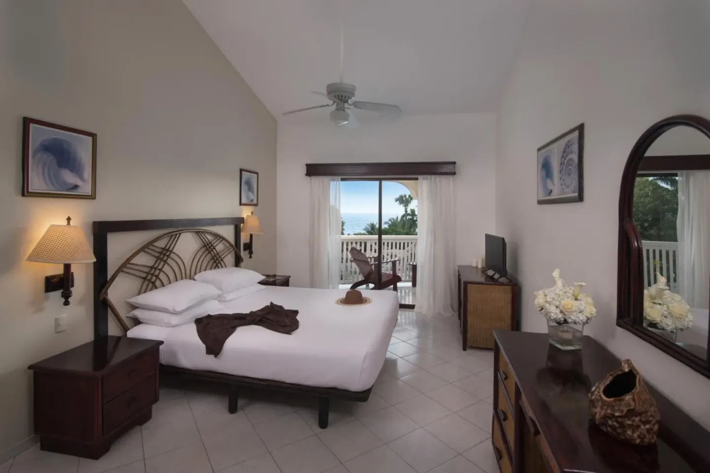 Guest room with king bed, dresser, and balcony view at Lifestyle Tropical Beach Resort & Spa.