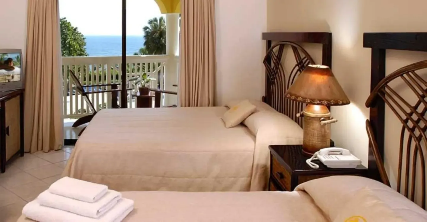 Guest room with two beds and balcony ocean view at Lifestyle Tropical Beach Resort & Spa.