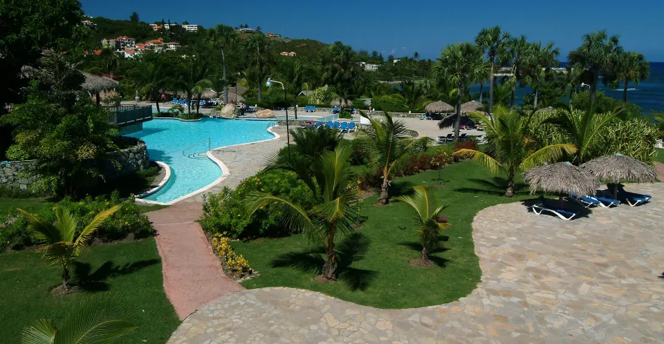 Landscaped pool grounds with palms and ocean views at Lifestyle Tropical Beach Resort & Spa.